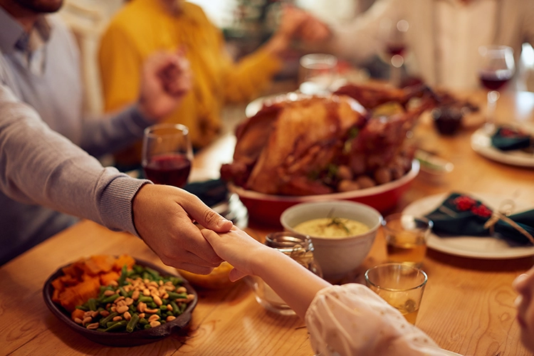 Family gathering around a festive table with a turkey dinner, sharing a moment of connection and warmth during the holidays.