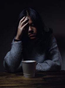 Poor indoor air quality services can help improve headaches. Woman with headache drinking cup of coffee